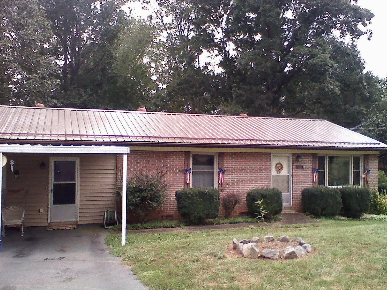 Bronze metal roof and carport on a brick ranch home — Roof Repair work by our crew in New Concord